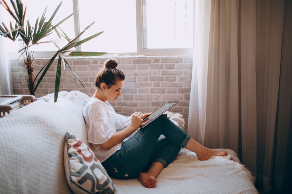 Woman sitting on a sofa using a tablet