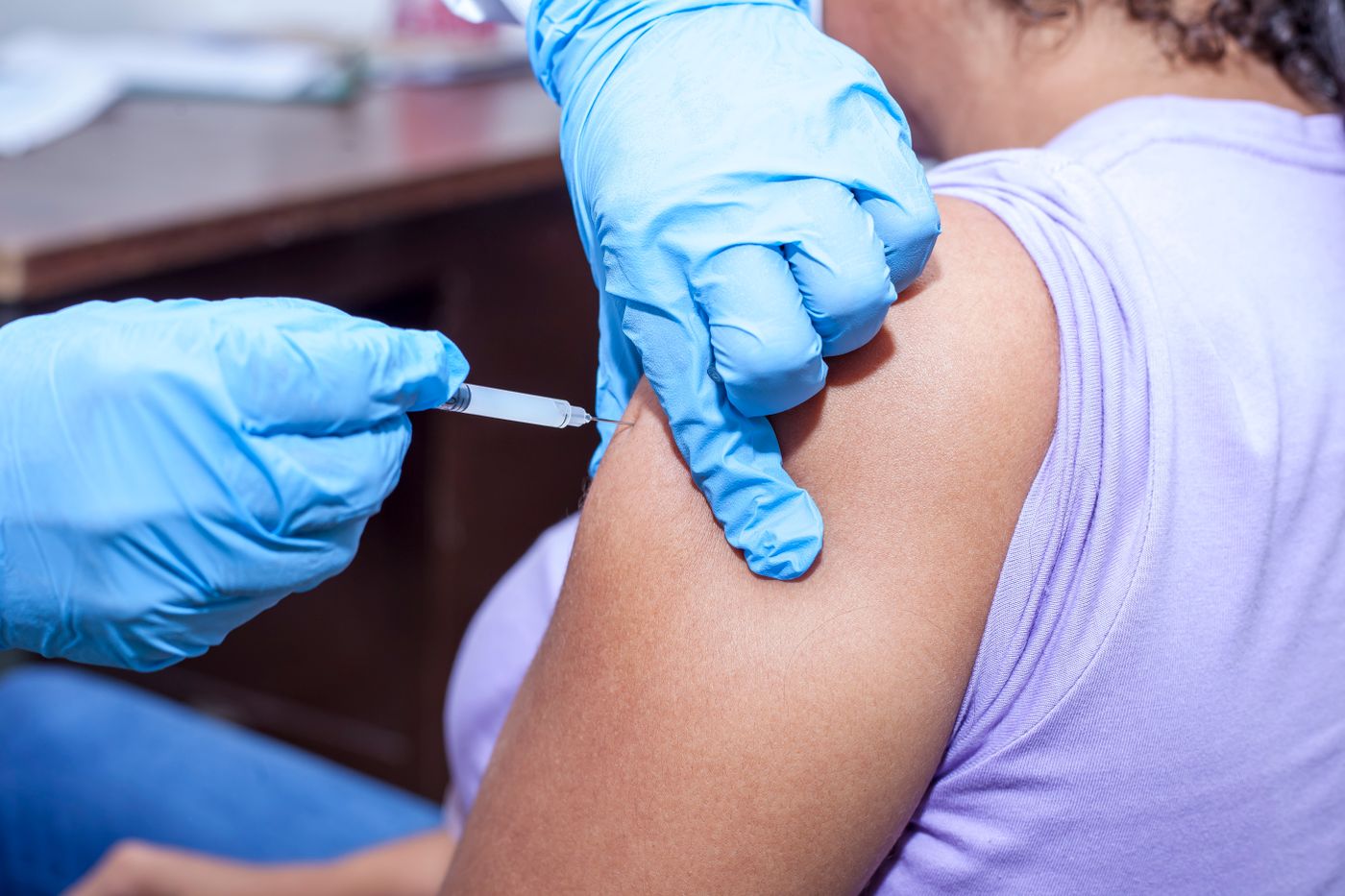 Healthcare worker giving a vaccine in the upper arm