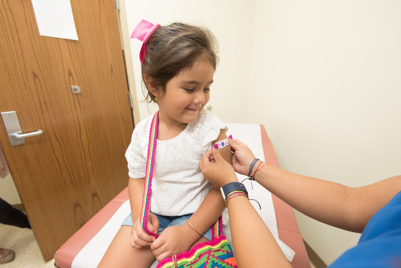 Young girl receiving a bandage after a vaccination