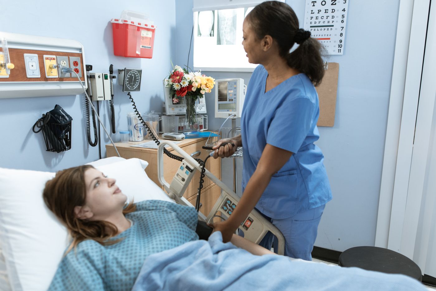 Nurse caring for a patient in a hospital bed